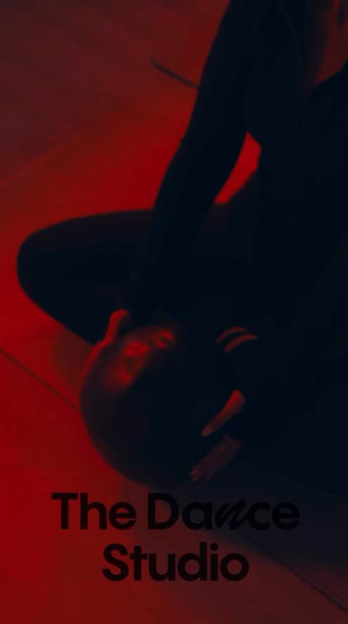 Red-lit title card from a Dance Studio class film, Saudi Arabia, showing one dancer and the studio name.